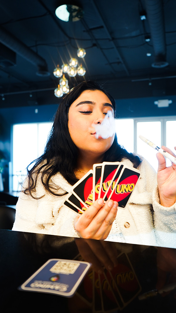 woman vaping while playing Uno